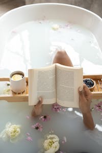 Peaceful bath scene with a book and flowers, creating a serene and tranquil atmosphere.